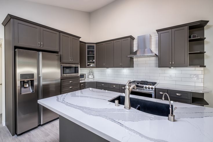 Stainless steel cabinets paired with bold granite countertops in a modern kitchen.